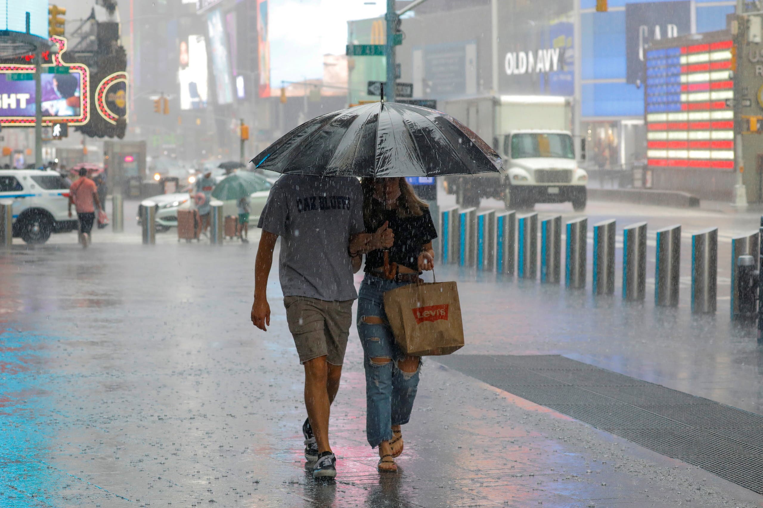 People walk through falling rain in Times Square as Tropical Storm Henri affects the region in Manhattan, New York City, US, August 23, 2021. (Reuters)
