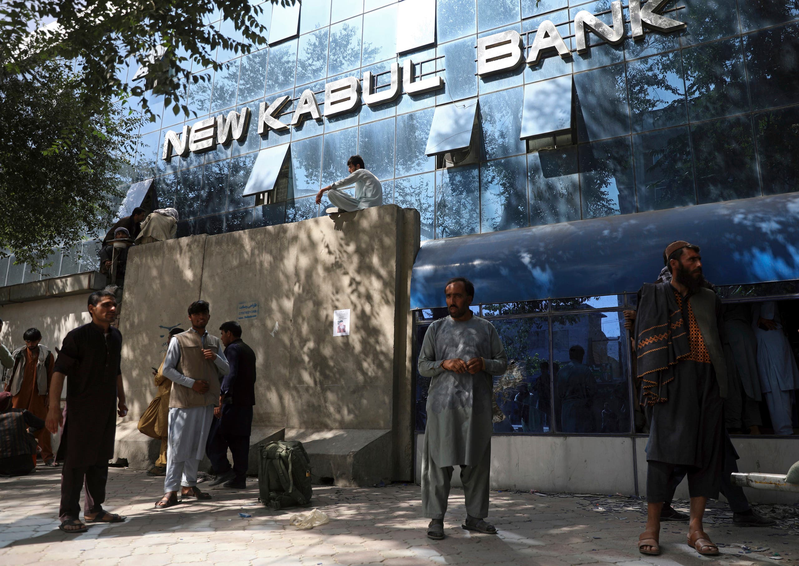 Afghans wait for hours to try to withdraw money, in front of Kabul Bank, in Kabul, Afghanistan, Sunday, Aug. 15, 2021. (AP)
