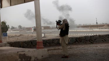 An Afghan soldier holds a gun and looks towards Taliban positions as smoke rises in the distance from clashes on the outskirts of Spin Boldak in Kandahar province, Afghanistan, July 16, 2021. This is one of the last known photographs by Reuters journalist Danish Siddiqui who was killed on the same day. (Reuters)