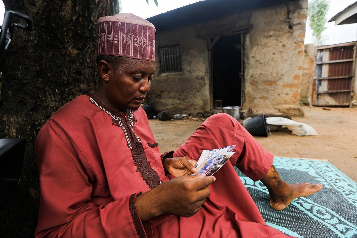 Aminu Salisu, a parent, looks at the pictures of one of the children kidnapped by bandits at Salihu Tanko Islamic school in Tegina, Niger State, Nigeria August 11, 2021. (Reuters)