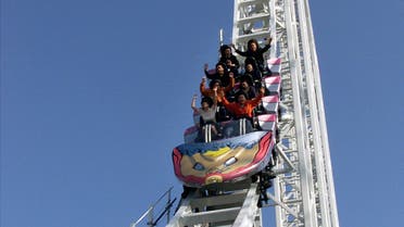 Guests raise their arms as they enjoy what is claimed to be the world's fastest roller-coaster called Dodonpaat Fujikyu Highland amusement park in Fuji-Yosida, west of Tokyo, December 3, 2001. The rides' top speed is 172-km per hour on the 1,200-metre track. The roller-coaster will be opened to the public at the end of December, 2001. Japan's Mt Fuji is seen in the background. REUTERS/Haruyoshi Yamaguchi