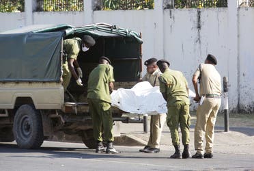 Tanzanian security forces remove the slain body of an attacker who was wielding an assault rifle, outside the French embassy in the Salenda area of Dar es Salaam, Tanzania, on August 25, 2021. (Reuters)