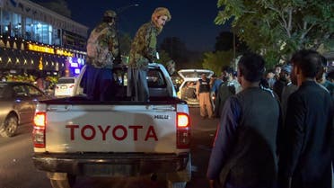 Taliban fighters stand on a pickup truck outside a hospital as volunteers bring injured people for treatment after two powerful explosions near the airport in Kabul, Aug. 26, 2021. (AFP)