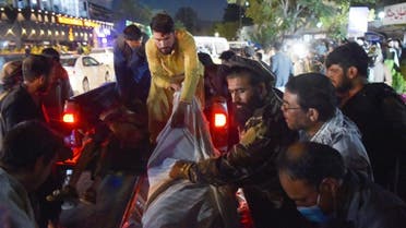 Volunteers and medical staff unload bodies from a pickup truck outside a hospital after two powerful explosions, which killed at least six people, outside the airport in Kabul on August 26, 2021. (AFP)