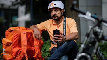 Former Afghan Communication Minister Sayed Sadaat sits with his gear as he works for the food delivery service Lieferando in Leipzig, Germany, August 26, 2021. (Reuters)