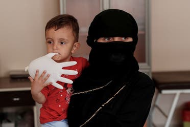 Afghan migrant Benevse and her two-year old son Rehimullah, caught by Turkish security forces after crossing illegally into Turkey from Iran, wait for a medical check at a migrant processing centre in the border city of Van, Turkey, on August 22, 2021. (Reuters)