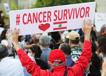 A man holds a sign during a sit-in demonstration as shortages of cancer medications spread, in front of the UN headquarters in Beirut, Lebanon, on August 26, 2021. (Reuters)