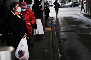 People walk through a neighborhood among those that have seen some of the highest number of city COVID-19 deaths on February 23, 2021 in the Queens borough of New York City. (AFP)