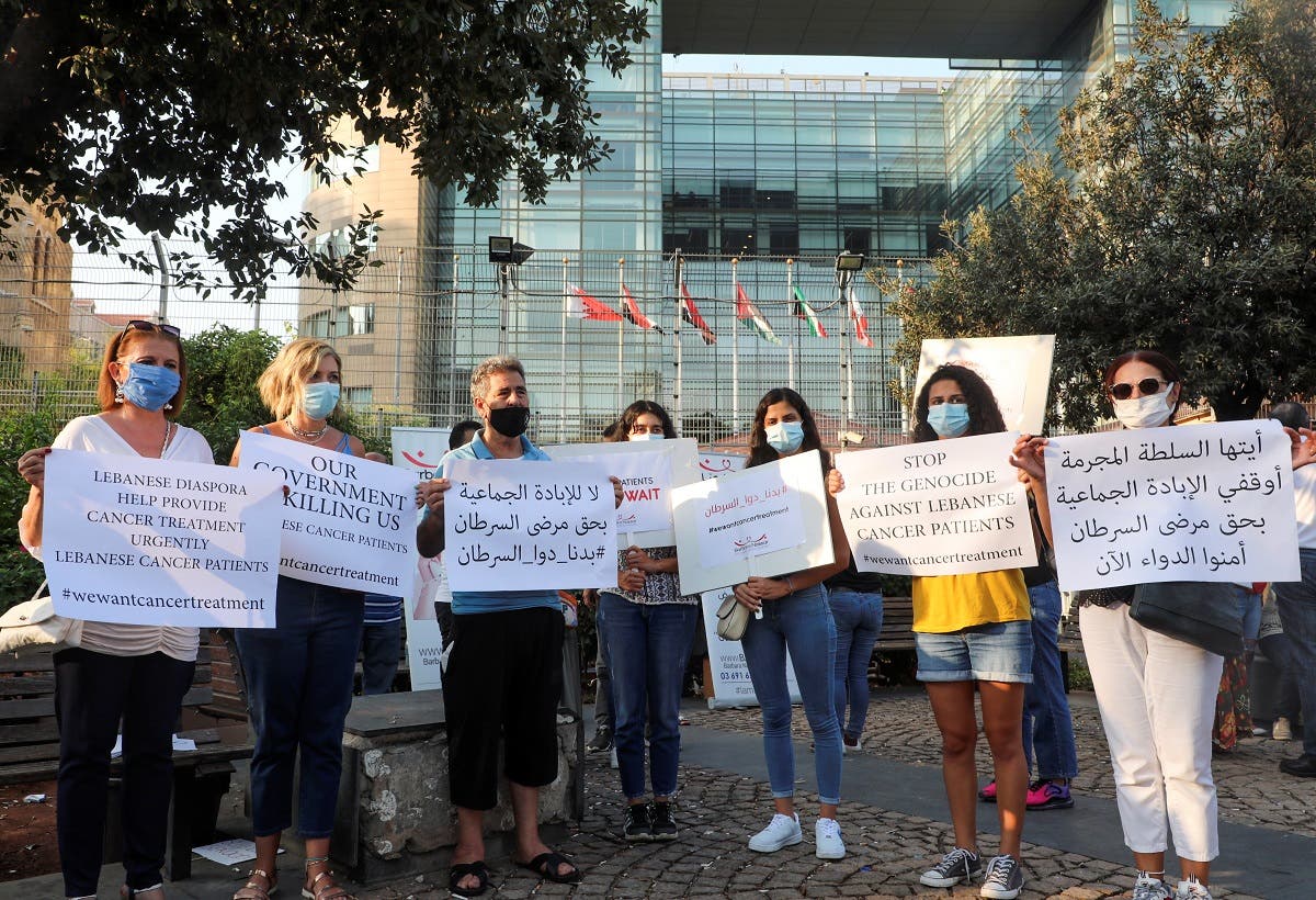 A file photo shows people hold signs during a sit-in demonstration as shortages of cancer medications spread, in front of the UN headquarters in Beirut, Lebanon August 26, 2021. (Reuters)