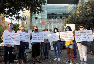 People hold signs during a sit-in demonstration as shortages of cancer medications spread, in front of the UN headquarters in Beirut, Lebanon August 26, 2021. (Reuters)
