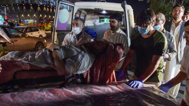 Volunteers and medical staff bring an injured man on a stretcher to a hospital for treatment after two powerful explosions, which killed at least six people, outside the airport in Kabul on August 26, 2021.
