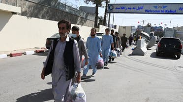 Afghans hoping to leave Afghanistan walk to the main entrance gate of Kabul airport in Kabul on August 28, 2021, following the Taliban stunning military takeover of Afghanistan. WAKIL KOHSAR / AFP