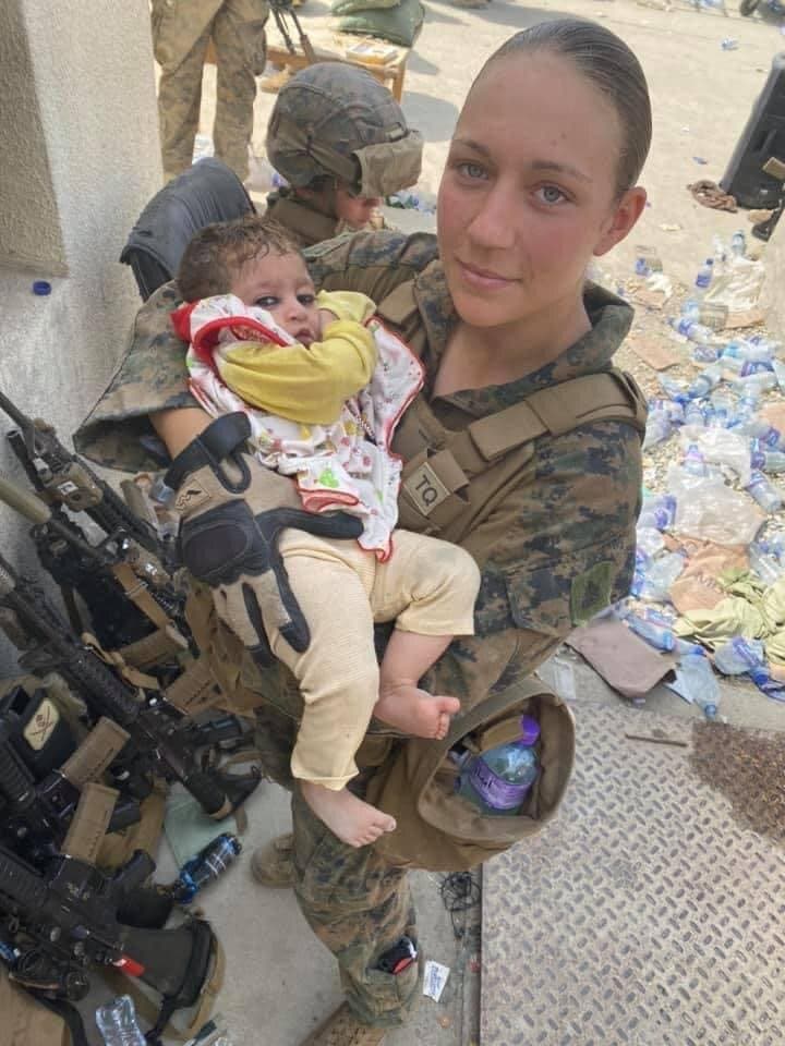 Nicole J holds Afghan baby at Kabul airport