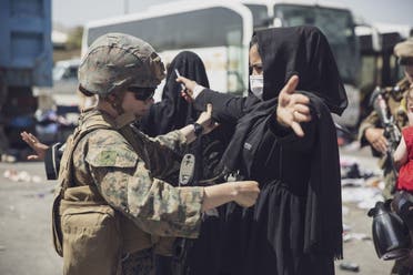 A US Marine checks a woman as she goes through the Evacuation Control Center (ECC) during an evacuation at Hamid Karzai International Airport, Kabul, Afghanistan, August 28, 2021. (Reuters)