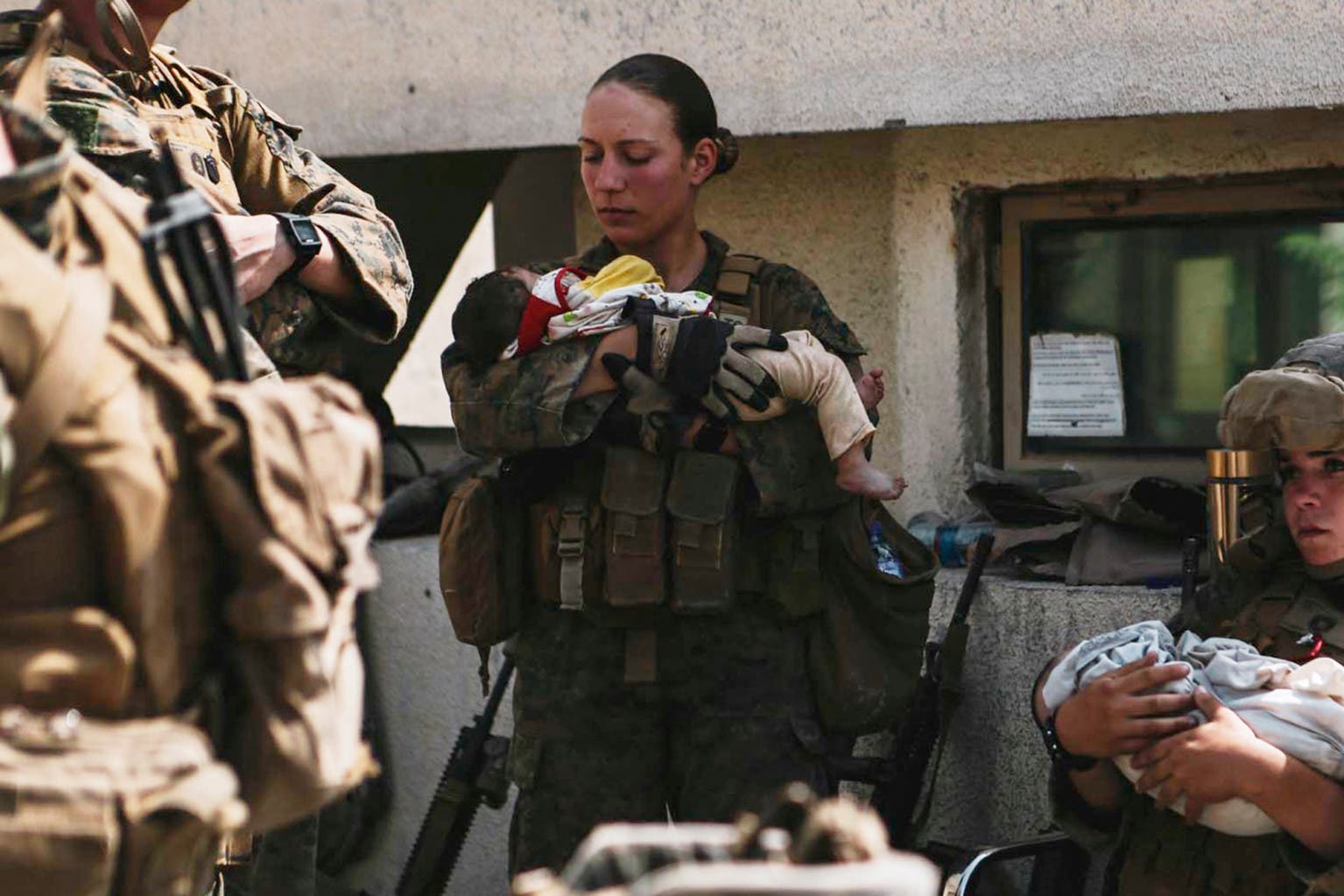 Nicole J holds Afghan baby at Kabul airport