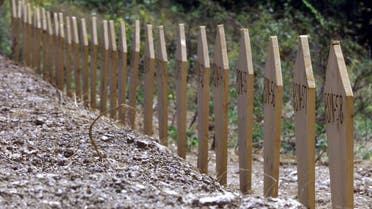 Dozens of graves marked with wooden markers where bodies of ethnic Albanians from Kosovo were buried are seen in this July 18, 2001 file photo, after they were unearthed from a mass grave in Petrovo Selo, about 150 kilometers east of Belgrade. (AP/Darko Vojinovic)