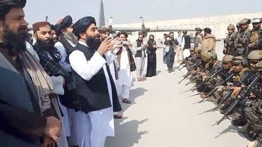 ذبيح الله مجاهد المتحدث باسم حركة طالبان يتحدث أمام مقاتلين من الحركة في مطار كابل