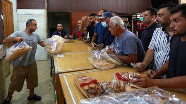 People queue to buy bread from a bakery, after the central bank decided to effectively end subsidies on fuel imports, in Sidon, Lebanon, on August 13, 2021. (Reuters)