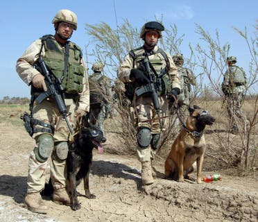United States Air Force Tech Sgt. John Mascolo, and his dog Ajax (L) await a helicopter pickup with Staff Sgt. Manny Garcia, and his dog Jimmy, outside Forward Operating Base Normandy in Iraq in this undated handout image obtained by Reuters December 2, 2011. (File photo: Reuters)