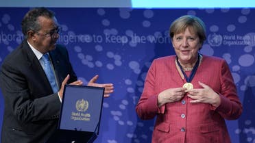German Chancellor Angela Merkel (R) smiles after she received a medal from Tedros Adhanom Ghebreyesus, Director-General of the World Health Organization (WHO) at the inauguration ceremony of the ‘WHO Hub For Pandemic And Epidemic Intelligence’ at the Langenbeck-Virchow building in Berlin, on September 1, 2021. (Michael Sohn/ Pool/AFP)