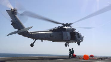 US Navy sailors connect pogo sticks, used to transport cargo, to an MH-60S Sea Hawk helicopter from the “Nightdippers” of Helicopter Sea Combat Squadron (HSC) 5 on the flight deck of the Nimitz-class aircraft carrier USS Abraham Lincoln (CVN 72) during a replenishment-at-sea, in Arabian Sea, June 7, 2019. (File photo: Reuters)