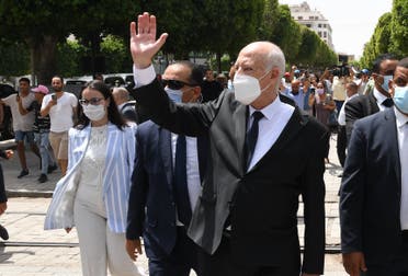 A handout picture provided by the Tunisian Presidency's official Facebook Page on August 1, 2021 shows President Kais Saied (C) gesturing as he walks protected by security while touring through Habib Bourguiba avenue in the center of the capital Tunis. (AFP)