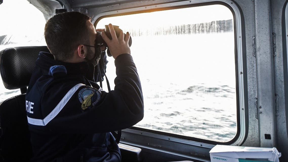 A French Maritime Gendarme from Boulogne-Sur-Mer, south of the port of Calais, looks through a pair of binoculars as he and his colleagues search for migrants trying to cross the Channel on August 12, 2021. (Francois Lo Presti/AFP)