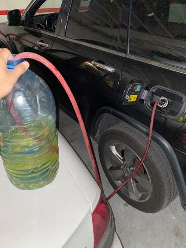 Filling up the car with gasoline purchased on the so-called black market. (Al Arabiya English)