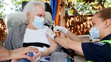 Medics prepare to apply an adhesive bandage after administering a COVID-19 vaccination dose to Marilyn Lurie, who is homebound suffering from frontotemporal dementia, in the backyard of Lurie's home on July 16, 2021 in Los Angeles, California.  (AFP)