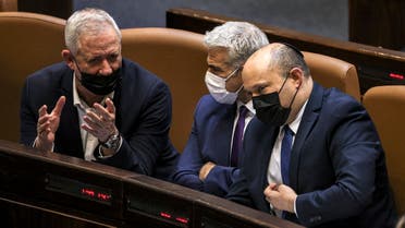 (L to R) Israeli Defense Minister Benny Gantz, Foreign Minister Yair Lapid, and Prime Minister Naftali Bennett sit together to attend a plenum session on the state budget on September 2, 2021. (Ahmad Gharabli/AFP)