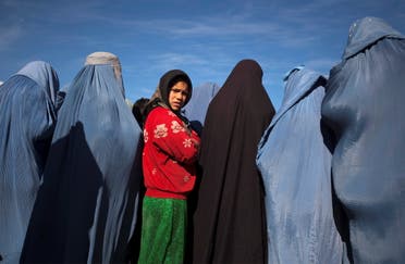 An Afghan girl stands among widows clad in burqas during a cash for work project by humanitarian organisation CARE International in Kabul, Afghanistan January 6, 2010. (Reuters)