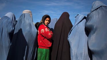 An Afghan girl stands among widows clad in burqas during a cash for work project by humanitarian organisation CARE International in Kabul, Afghanistan January 6, 2010. (Reuters)