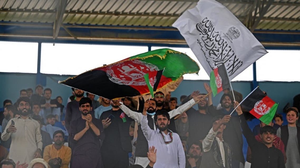 Spectators wave Afghanistan's and Taliban flags as they watch the Twenty20 cricket trial match being played between two Afghan teams 'Peace Defenders' and 'Peace Heroes' at the Kabul International Cricket Stadium in Kabul on September 3, 2021. (AFP)