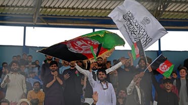 Spectators wave Afghanistan's and Taliban flags as they watch the Twenty20 cricket trial match being played between two Afghan teams 'Peace Defenders' and 'Peace Heroes' at the Kabul International Cricket Stadium in Kabul on September 3, 2021. Aamir QURESHI / AFP