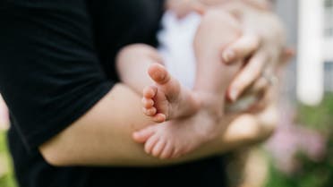 Woman holding a newborn baby. (Unsplash, Wes Hicks)