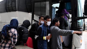 A man gestures as he and other Afghan refugees board a bus after arriving at Dulles International Airport on August 27, 2021 in Dulles, Virginia, after being evacuated from Kabul following the Taliban takeover of Afghanistan. (AFP)