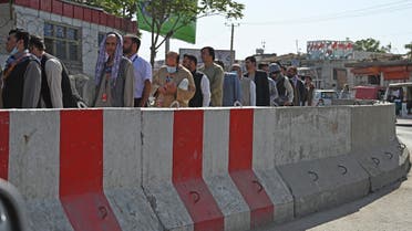 Airport workers stand in a queue at a check point before entering the Kabul International Airport in Kabul on September 4, 2021.