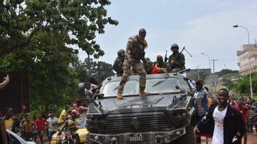 People celebrate in the streets with members of Guinea's armed forces after the arrest of Guinea's president, Alpha Conde, in a coup d'etat in Conakry, September 5, 2021. Guinean special forces seized power in a coup on September 5, arresting the president and imposing an indefinite curfew in the poor west African country.