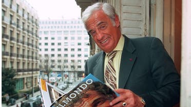In this file photo taken on April 4, 1996 French actor Jean-Paul Belmondo flips through his biography in Paris. (Vincent Amalvy/AFP)