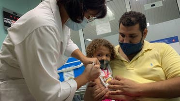  In this file photo taken on August 24, 2021 Pedro Montano holds his daughter Roxana Montano, 3, as she is inoculated against COVID-19 with Cuban vaccine Soberana Plus, at the Juan Manuel Marquez hospital in Havana. (AFP)