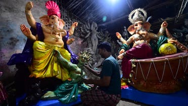 An artist gives the finishing touches to an idol of the elephant-headed Hindu God Ganesha with a figure depicting a coronavirus at a workshop ahead of the Ganesh Chaturthi festival in Allahabad on September 7, 2021. (File photo: AFP)