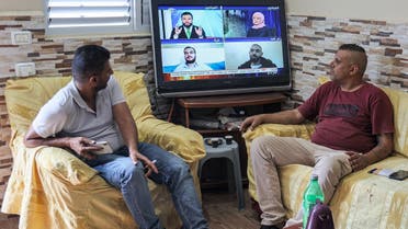 Family members of of Zakaria Zubeidi, one of six Palestinian prisoners who escaped from Israel's Gilboa prison, watch a news bulleting on a television as they await any information about him, at their home in the Jenin camp for Palestinian refugees in the north of the occupied West Bank, on September 7, 2021. (AFP)
