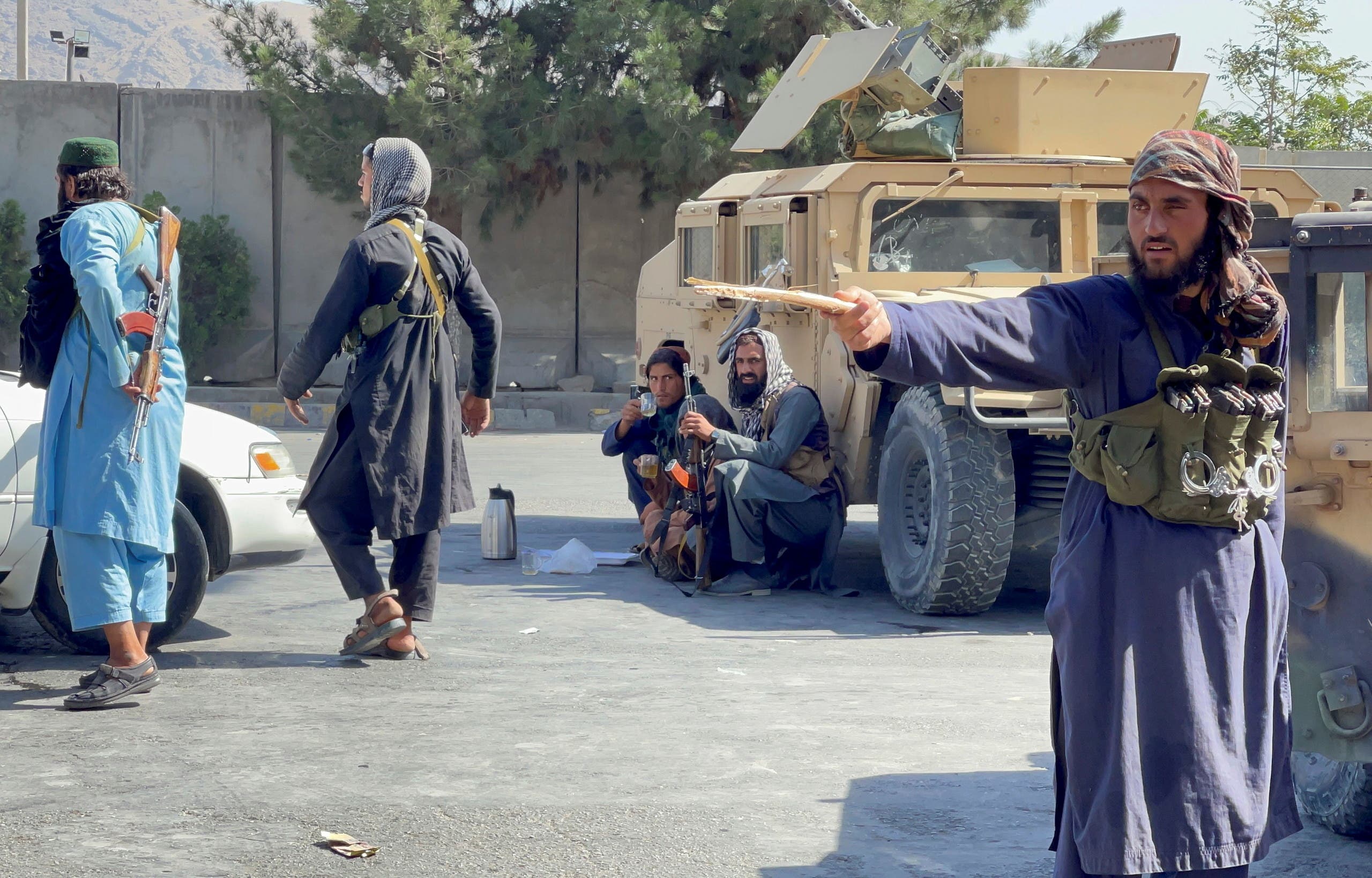 Taliban member points to protesters (Reuters)