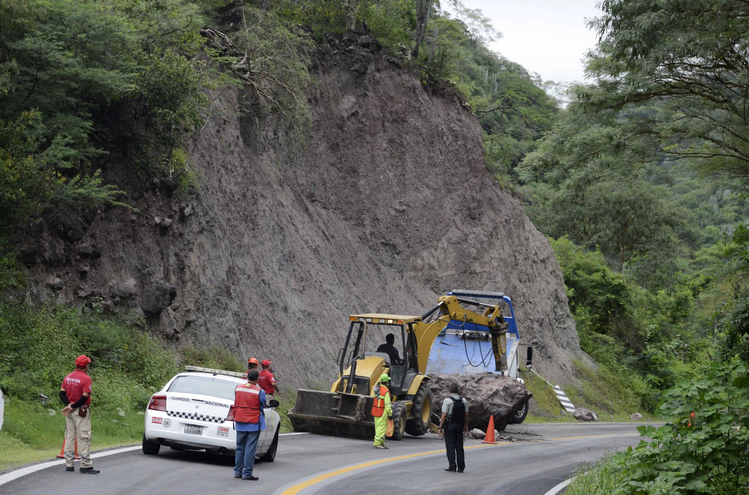 Workers remove rocks on the Acapulco-Iguala highway after a quake in Acapulco, Guerrero state, Mexico on September 8, 2021. (AFP)