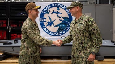 Vice Adm. Brad Cooper, left, commander of U.S. Naval Forces Central Command, U.S. 5th Fleet and Combined Maritime Forces, shakes hands with Capt. Michael D. Brasseur, the first commodore of Task Force (TF 59) during a commissioning ceremony for TF 59 onboard Naval Support Activity Bahrain, Sept. 9. (US Navy)