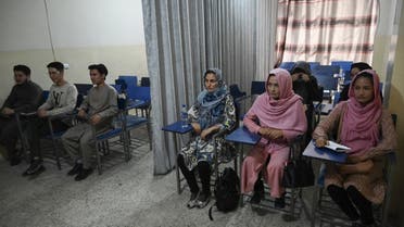 Students attend a class bifurcated by a curtain separating males and females at a private university in Kabul on September 7, 2021, to follow the Taliban's ruling. (AFP)