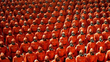 Personnel in orange hazmat suits march during a paramilitary parade held to mark the 73rd founding anniversary of the republic at Kim Il Sung square in Pyongyang in this undated image supplied by North Korea's Korean Central News Agency on September 9, 2021. (Reuters)