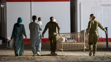 A handout photo taken on August 21 and received on August 22, 2021 from the Australian Defence Force shows people being escorted to their quarters following their evacuation flight from Afghanistan, at the Al Minhad Air Base some 25 kilometres south of Dubai. (File photo: AFP)