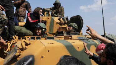 A Turkish soldier gestures as people stand on a military vehicle during a protest against the agreement on joint Russian and Turkish patrols, at M4 highway in Idlib province, Syria. (File photo: Reuters)