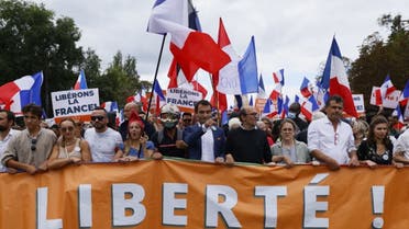 Leader of French nationalist party Les Patriotes (The Patriots) Florian Philippot (C) leads the march during a demonstration against France's Covid-19 health pass in Paris on September 11, 2021. (AFP)